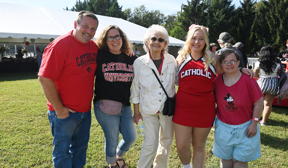 A CUA cheerleader poses with her family